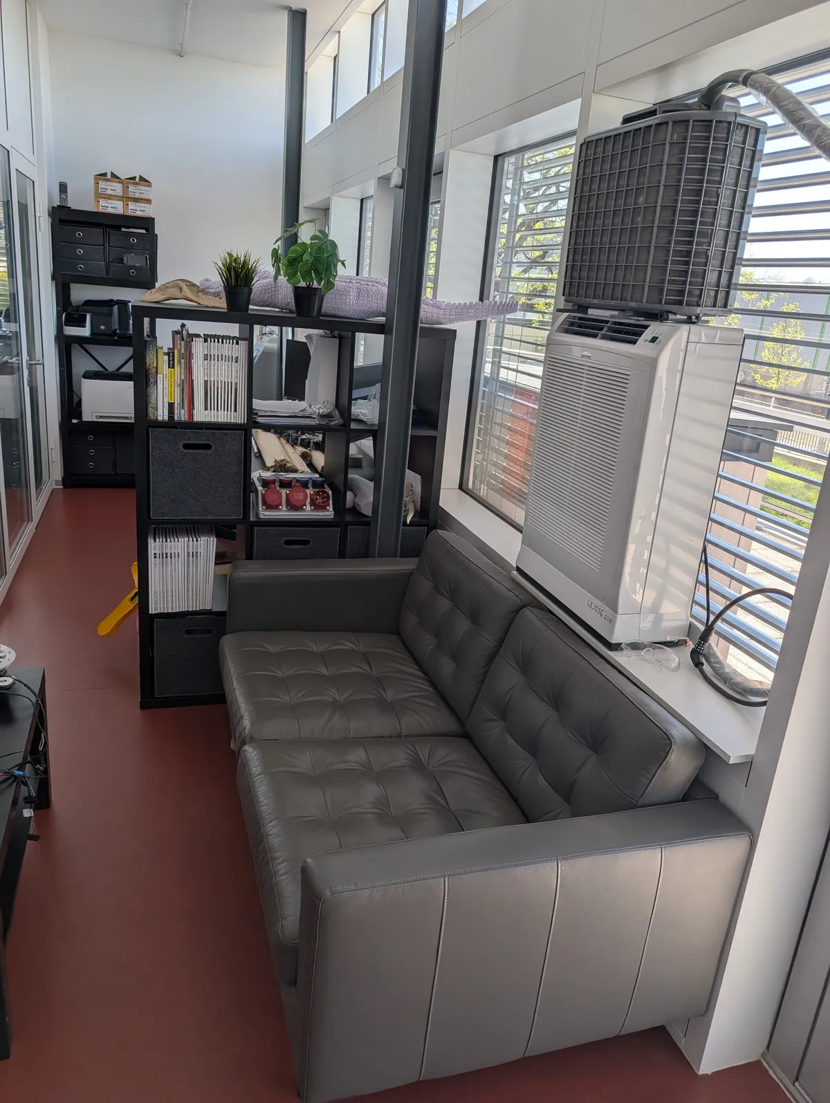 Comfortable lounge area with sofa, reading material, and kitchen amenities.